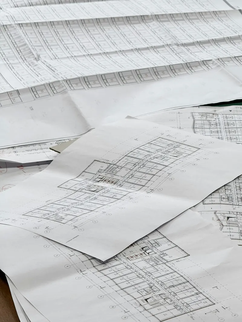 Bouwplannen van een renovatie uitgespreid op een werktafel