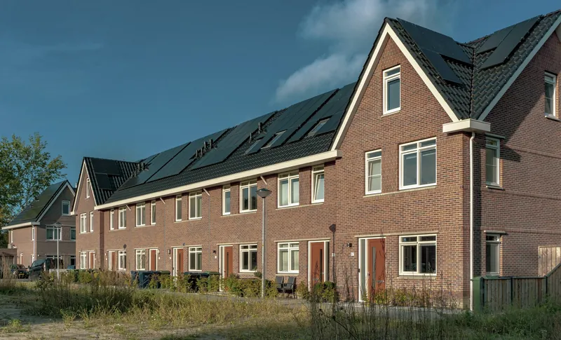 Rij bakstenen gezinswoningen met pannendaken, het type woning dat wij renoveren